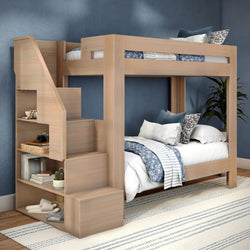 Light wood twin-over-twin bunk bed with built-in storage staircase, space-saving design and blue patterned bedding in kids' bedroom