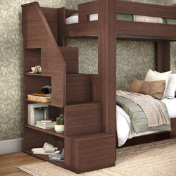 Dark wood space-saving bunk bed with staircase storage and built-in shelving in cozy bedroom with floral wallpaper