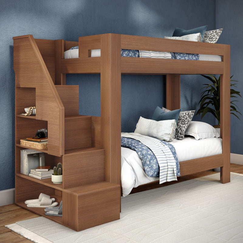 Modern wooden bunk bed with built-in staircase storage, blue patterned bedding and pillows in a contemporary kids' bedroom