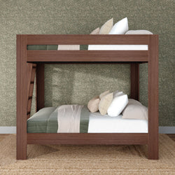 Solid wood bunk bed with ladder, neutral pillows and green quilt in a cozy kids' bedroom with floral wallpaper and jute rug