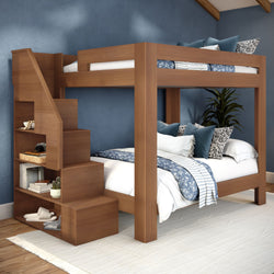 Modern solid wood loft bunk bed with built-in storage stairs, navy blue floral bedding, throw pillows and plant in a stylish kids' bedroom