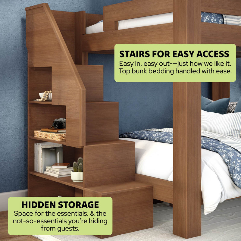 Wooden bunk bed with built-in staircase and hidden storage shelves, navy patterned bedding and blue accent wall