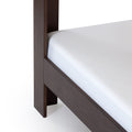 Close-up of dark wood bed frame leg and side rail with white mattress corner, modern platform bed detail optimized for bedroom furniture listings