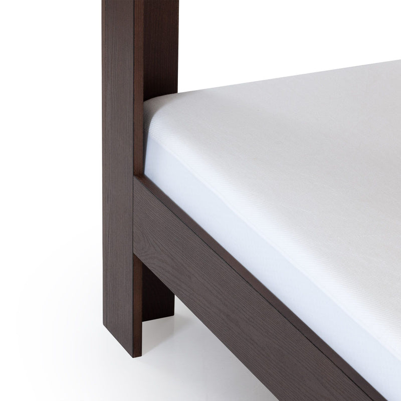 Close-up of dark wood bed frame leg and side rail with white mattress corner, modern platform bed detail optimized for bedroom furniture listings