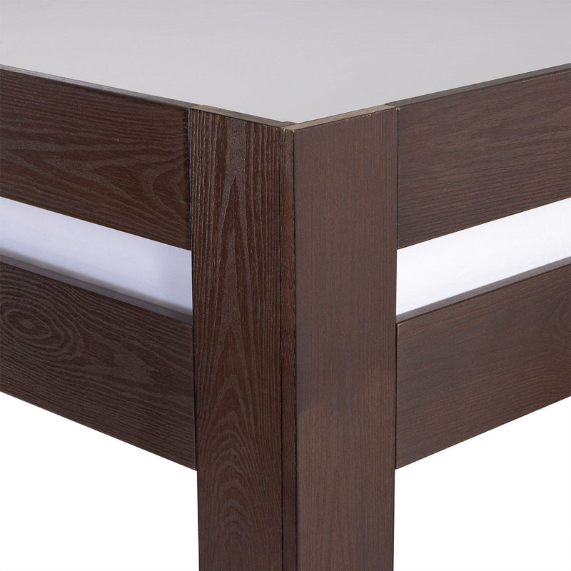 Close-up of dark brown wooden platform bed frame corner showing vertical post, horizontal slats, oak grain finish and mattress edge