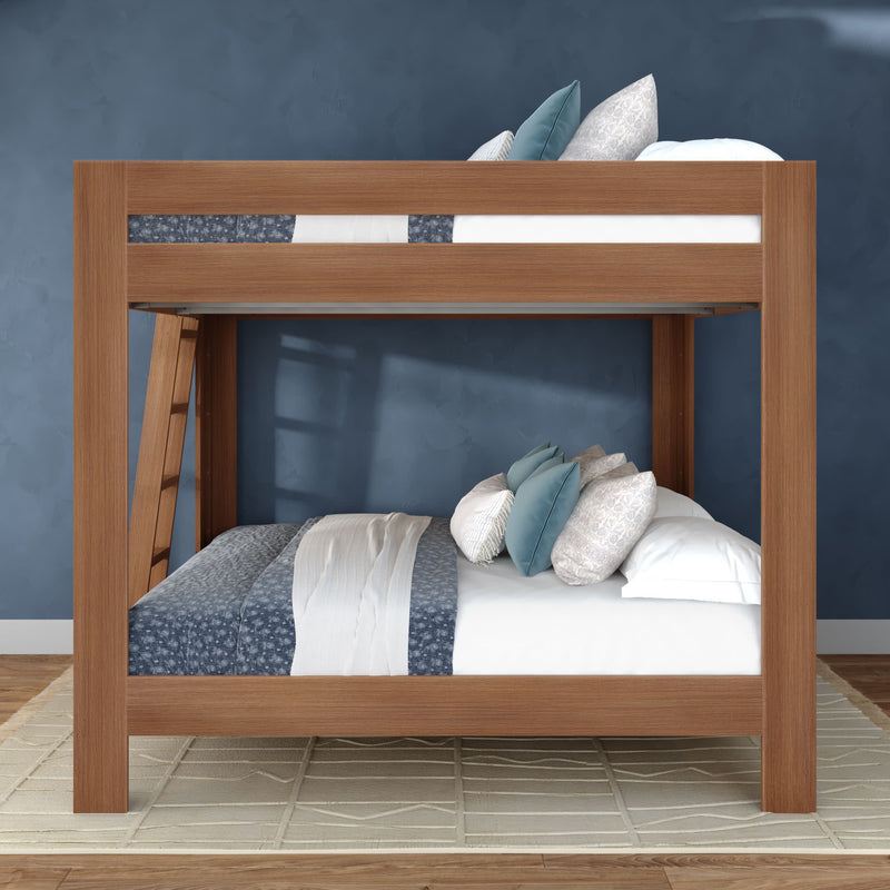 Modern solid wood bunk bed with ladder, blue patterned bedding and decorative pillows in a cozy bedroom with textured blue wall and neutral rug