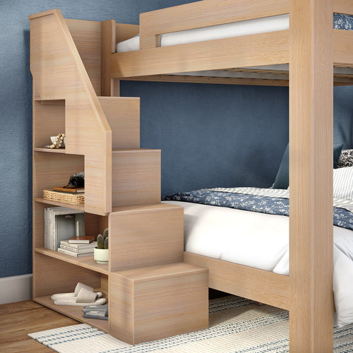 Light oak wooden loft bunk bed with built-in staircase and open storage shelves, space-saving bedroom furniture against blue textured accent wall with patterned bedding