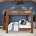 Modern solid wood bunk bed with built-in staircase storage, blue floral bedding and decorative pillows in a coastal-style kids' bedroom.