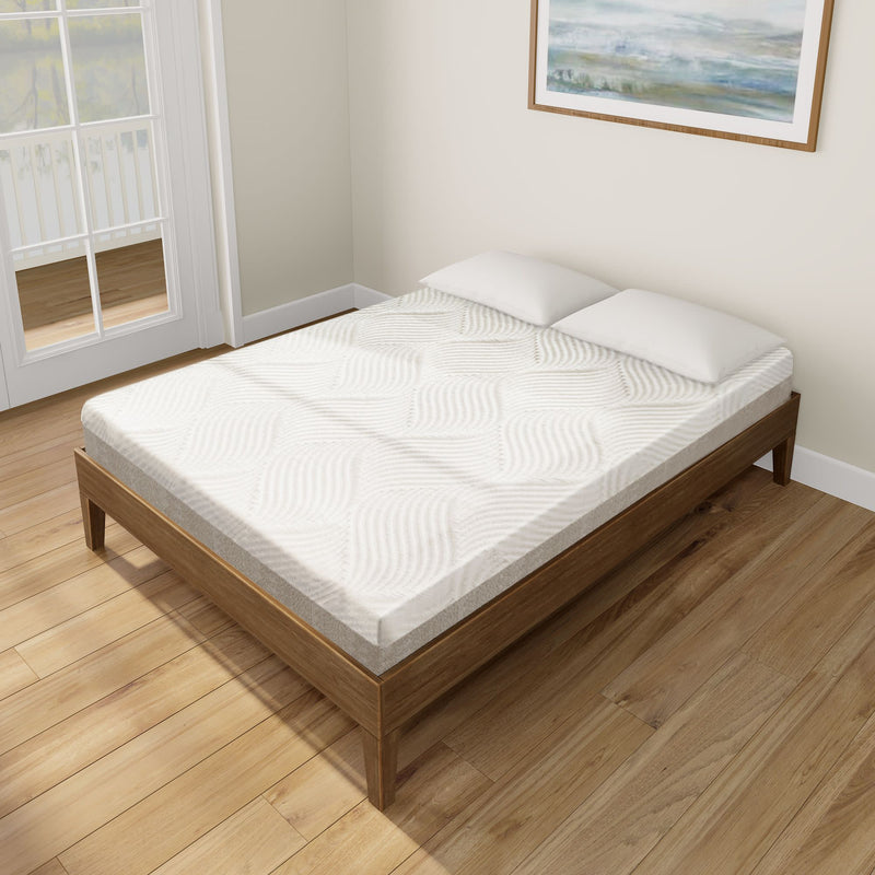 Queen-size memory foam mattress on wooden bed frame in a bright bedroom with hardwood floors.