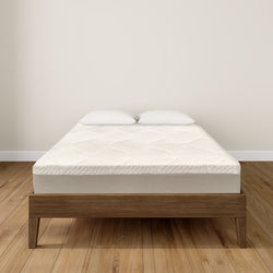 Modern wooden bed frame with a comfortable mattress and two pillows in a minimalist bedroom setting.