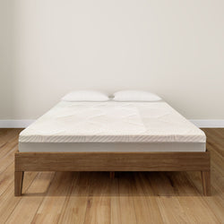 Queen-size bed with wooden frame and comfortable mattress on polished hardwood floor.