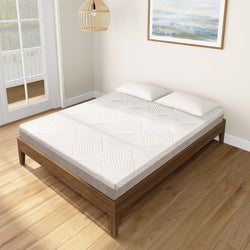 Queen size memory foam mattress with white patterned cover on wooden bed frame in modern bedroom.