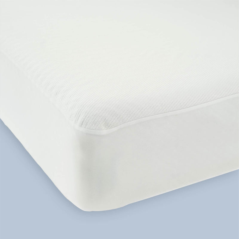 Premium white mattress protector with seamless fit on blue background.