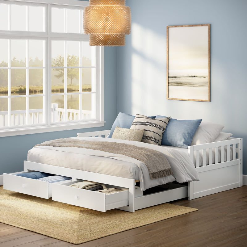 White wooden daybed with underbed storage drawers in a coastal-style bedroom with light blue walls, large window overlooking a lake, woven pendant light, neutral layered bedding and hardwood floors