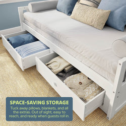 White wooden daybed with pull-out under-bed storage drawers holding pillows and blankets — space-saving guest room sofa bed and bedroom furniture