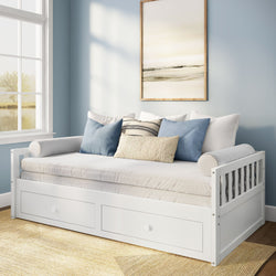 White wooden daybed with built-in storage drawers, blue and beige throw pillows, framed abstract art and large window in light-blue coastal-style guest room