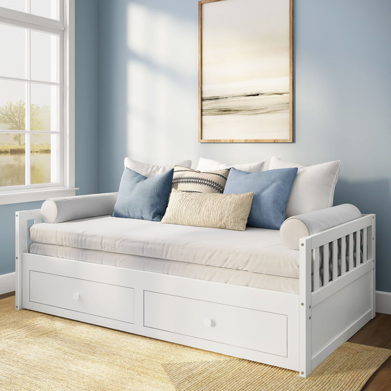 White wooden daybed with built-in storage drawers, blue and beige throw pillows, framed abstract art and large window in light-blue coastal-style guest room
