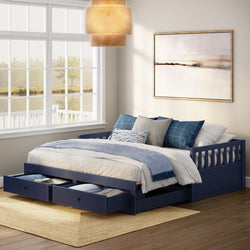 Navy blue wooden daybed with two under-bed storage drawers, white and blue bedding and pillows, framed abstract art, rattan pendant and large window with lake view in a bright coastal-style bedroom