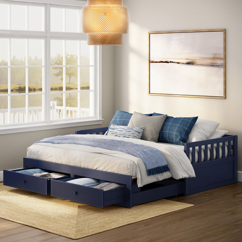 Navy blue wooden daybed with two under-bed storage drawers, white and blue bedding and pillows, framed abstract art, rattan pendant and large window with lake view in a bright coastal-style bedroom