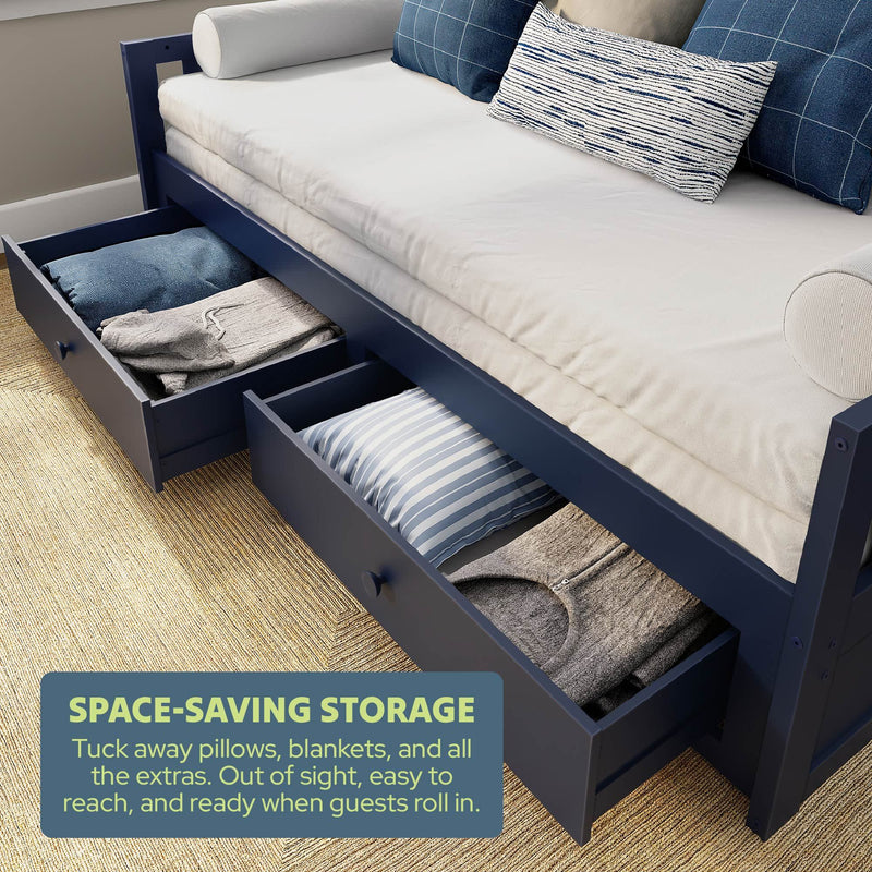 Navy daybed with open under-bed storage drawers holding pillows and blankets, a space-saving guest room storage solution