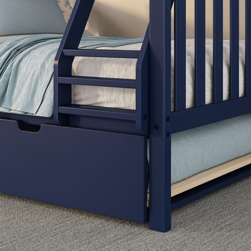 Close-up of navy blue wooden kids bunk bed ladder and safety rail with light blue bedding and under-bed trundle drawer