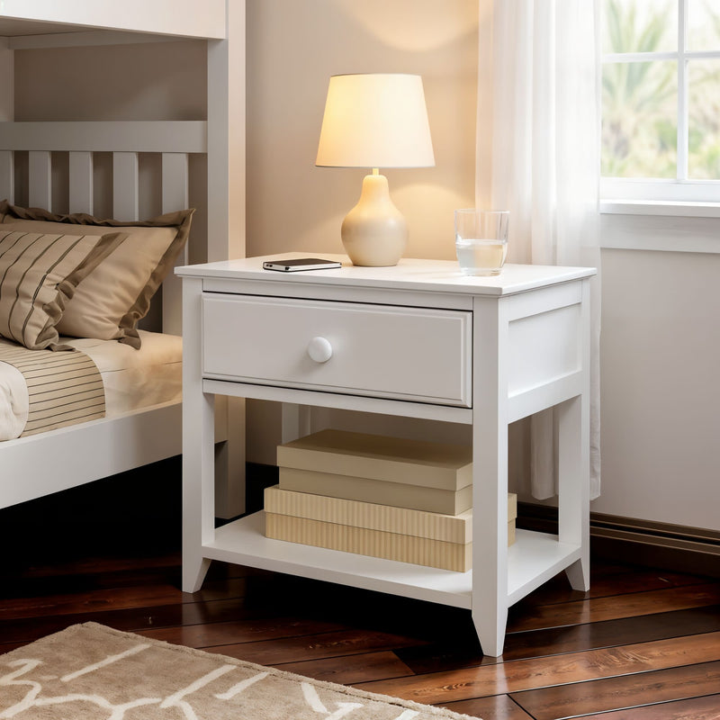 White bedside table with lamp and decorative items in cozy bedroom setting.