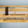 Wooden bed rail shelf with black water bottle for bedroom storage solutions.