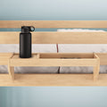 Wooden bed with built-in cup holder featuring a black water bottle.