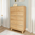 Natural pine five-drawer tall dresser with round knobs in a light modern bedroom, mid-century modern bedroom storage chest