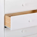 White dresser with partially open drawer revealing natural wood interior and round white knobs, modern bedroom storage chest of drawers