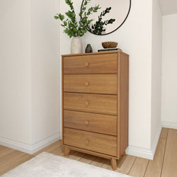 Wooden tallboy dresser with plants and mirror in modern bedroom setting.