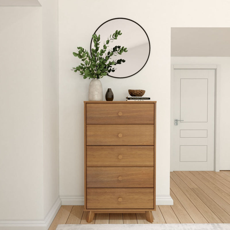 Modern wooden dresser with plants and decorative items, placed under a round mirror in a contemporary room.