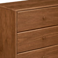Close-up of brown wooden 3-drawer dresser with round knobs and visible wood grain, bedroom storage furniture in mid-century modern style