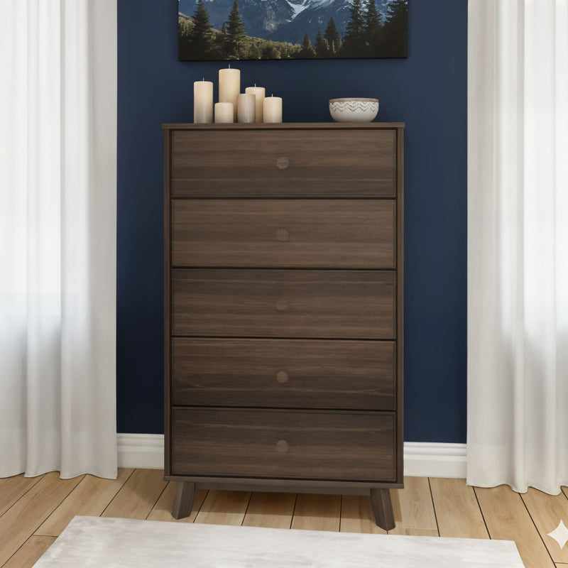Mid-century modern tall five-drawer walnut dresser chest of drawers in a styled navy blue bedroom with hardwood floors, white curtains, decorative candles, ceramic bowl and mountain wall art
