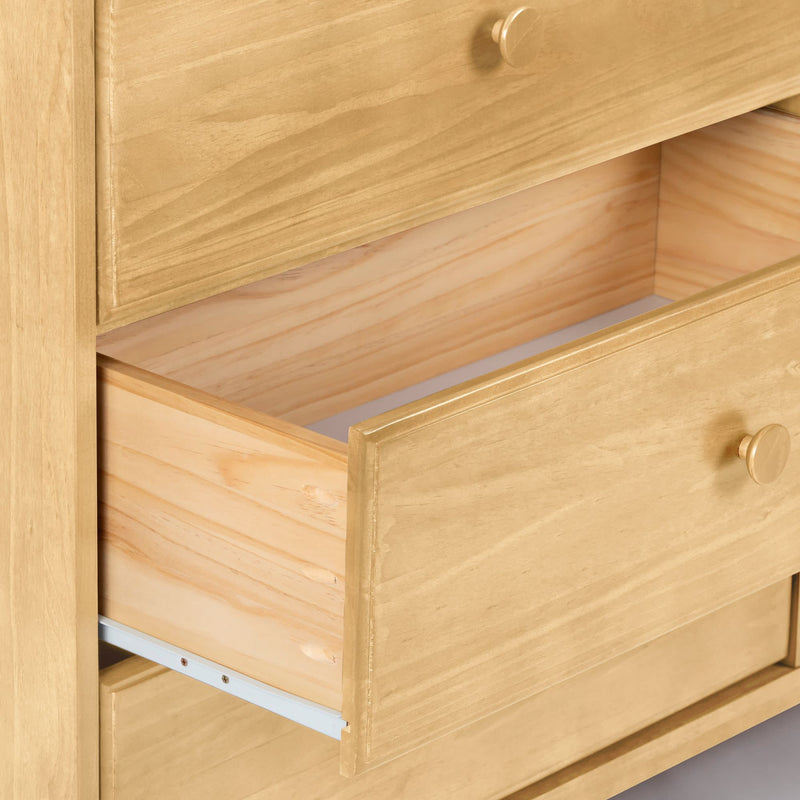 Open wooden dresser drawer in light pine finish showing wood grain, wooden knob, and metal side rail — bedroom storage furniture