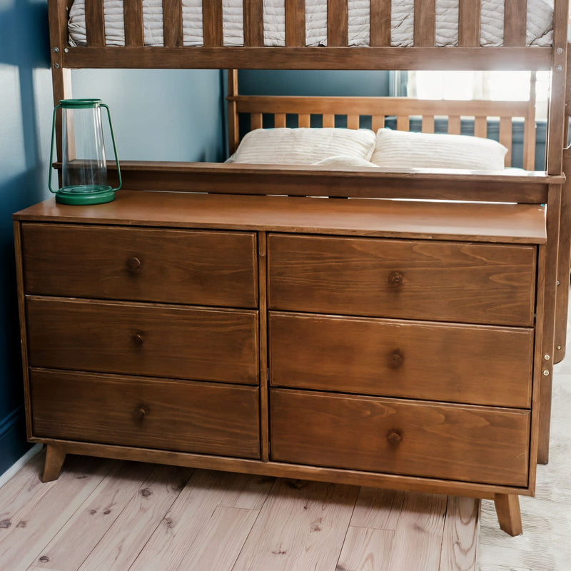 Solid wood six-drawer mid-century dresser with oak finish and mirror in teal bedroom, green lantern accent and wood plank floor