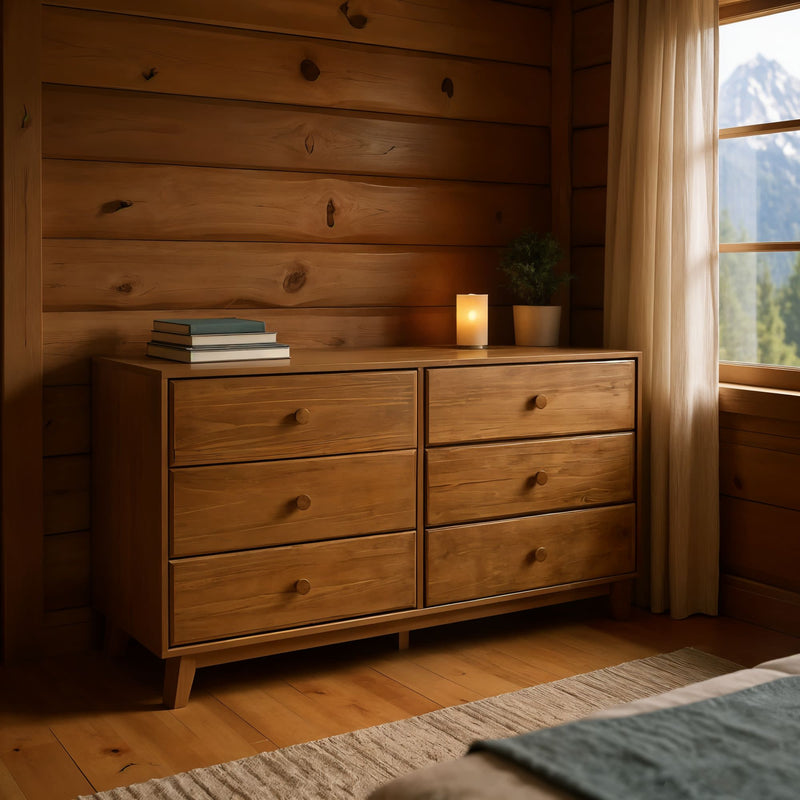 Wooden dresser in cozy cabin bedroom with mountain view through the window.