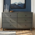 Gray six-drawer wooden dresser against blue accent wall with mountain artwork, white candles and decorative bowl — modern bedroom storage