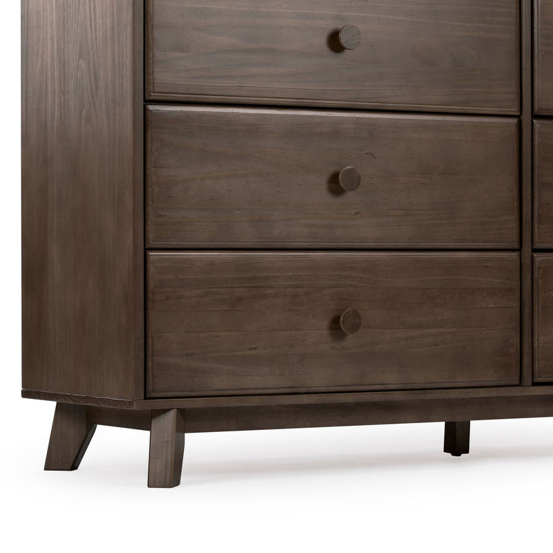Mid-century modern walnut dresser close-up showing three wooden drawers with round knobs, tapered legs and rich brown wood grain finish
