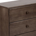 Close-up of a brown three-drawer wooden dresser with round knobs and smooth walnut finish, modern bedroom storage chest