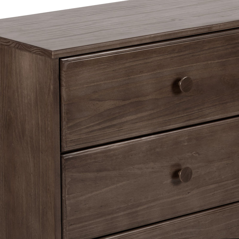 Close-up of a brown three-drawer wooden dresser with round knobs and smooth walnut finish, modern bedroom storage chest