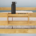 Wooden bed shelf with black water bottle on a bunk bed for dorm room organization.