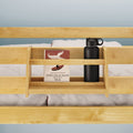 Wooden bed shelf with "The Old Man and the Sea" book and black water bottle.