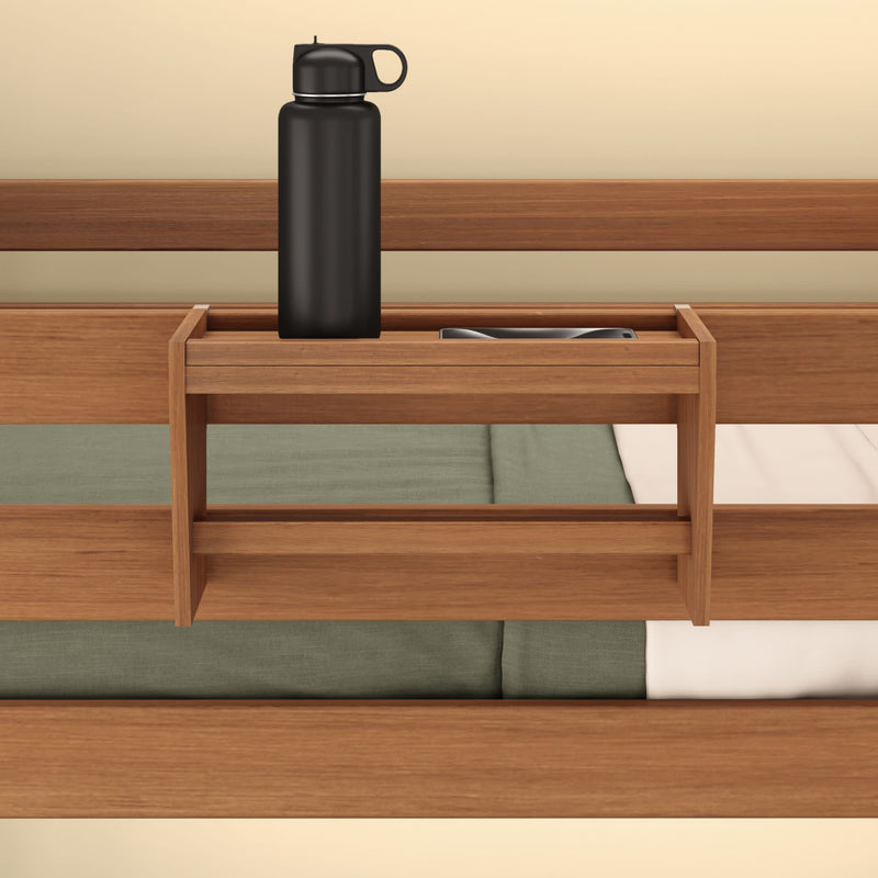 Wooden bedside shelf with black water bottle and book, attached to bed frame for convenient storage.