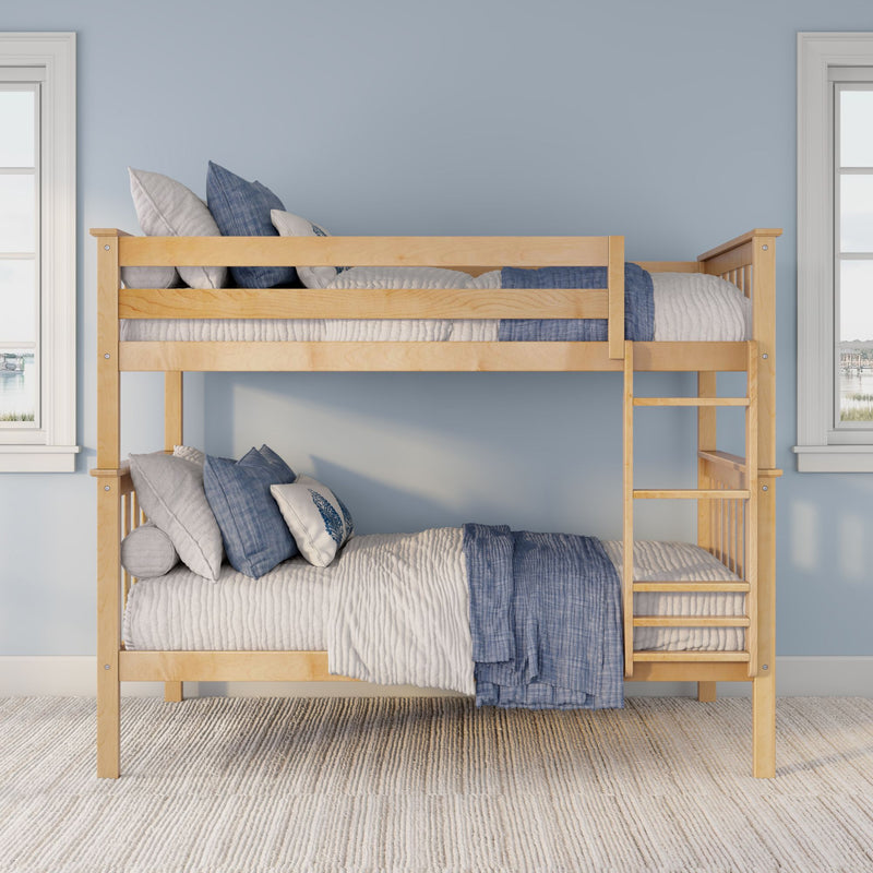 Natural wood bunk bed with ladder, blue and white bedding and pillows against a pale blue wall in a bright bedroom