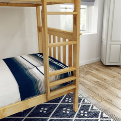 Wooden bunk bed with striped bedding in a modern bedroom setting featuring hardwood floors and a patterned rug.