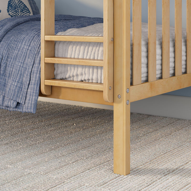 Close-up of light natural wood bunk bed ladder and leg with blue quilted bedding, white mattress and textured woven rug in bedroom