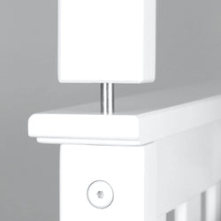 Close-up of a white wooden crib railing with metal hardware, showcasing sturdy construction and modern design for baby safety.