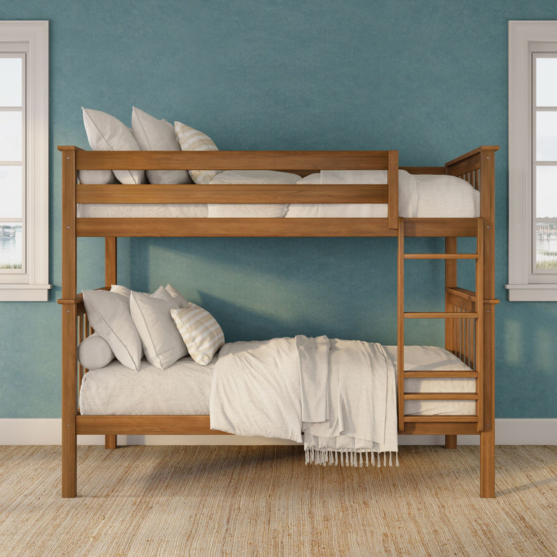 Wooden bunk bed with ladder, white bedding and striped pillows against a teal textured wall with woven rug
