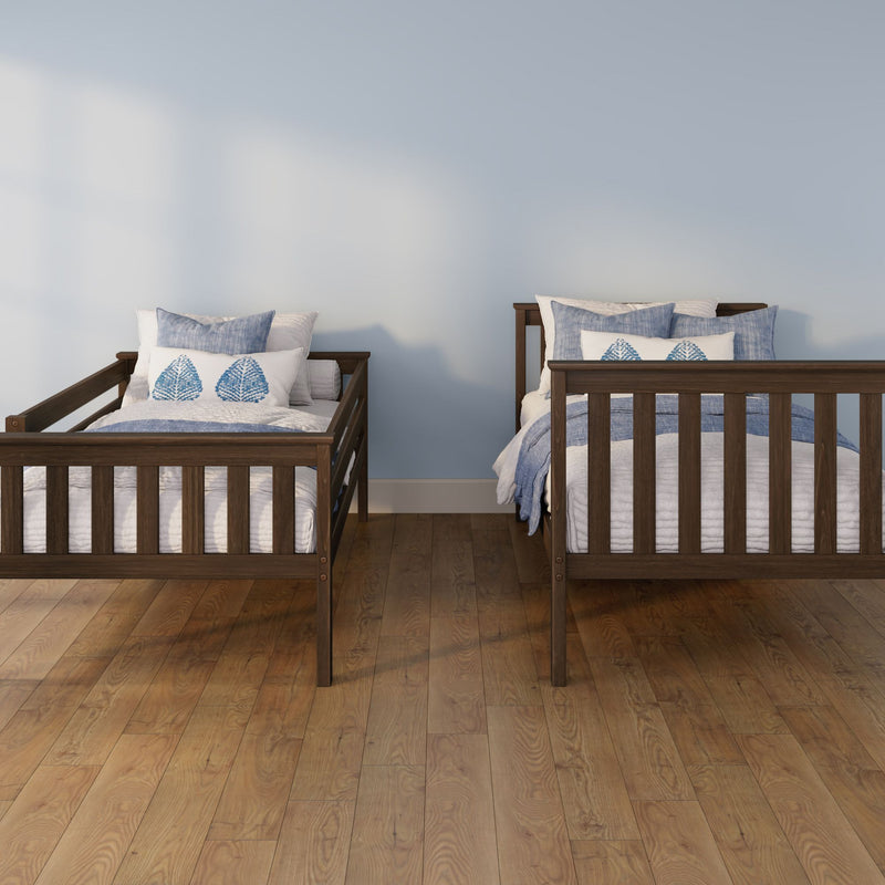Twin wooden beds with blue-and-white coastal bedding against a light blue wall over hardwood floors